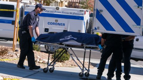 Los Angeles County Coroner officials remove a body from a home where five bodies were found dead, in the city of Lancaster in the high desert Antelope Valley north of Los Angeles, Monday, Nov. 29, 2021. A Los Angeles County Sheriff's Department statement says deputies found a woman, a girl and three boys with gunshot wounds and paramedics pronounced them dead at the scene. The department says the children's father showed up at the Lancaster sheriff's station and was arrested on suspicion of five murders after being interviewed by detectives. (AP Photo/Ringo H.W. Chiu)