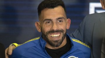 Former Boca Juniors star Carlos Tevez smiles wearing the team´s jersey during his presentation as the new coach for Rosario Central, in Rosario, Argentina, Tuesday, June 21, 2022. (AP Photo/Franco Trovato)