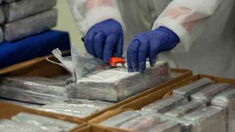 A member of the Portuguese police opens a packet of cocaine being displayed for the media at the police headquarters in Lisbon, Tuesday, May 2, 2023. Police said it seized 4.2 tons of cocaine that entered Portugal concealed in a shipment of bananas proceeding from Latin America. (AP Photo/Armando Franca)