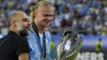 Manchester City's head coach Pep Guardiola, left, celebrates with Manchester City's Erling Haaland after winning the UEFA Super Cup Final soccer match between Manchester City and Sevilla at Georgios Karaiskakis stadium in Piraeus port, near Athens, Greece, Wednesday, Aug. 16, 2023. (AP Photo/Thanassis Stavrakis)