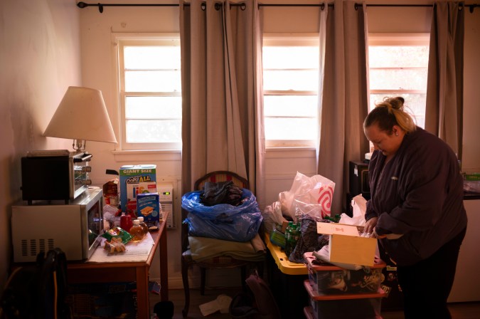 Brandi Arresondo, a homeless woman who was bused to a motel after her encampment was cleaned up as part of Los Angeles Mayor Karen Bass' Inside Safe program, goes through her belongings in her room in Culver City, Calif., Tuesday, Nov. 28, 2023. "I have a lot of health problems, and dealing with it on the street is hard," said Arresondo. "I was very happy to be the first one on the bus." (AP Photo/Jae C. Hong)