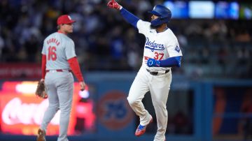 Los Angeles Dodgers' Teoscar Hernandez celebrates his three-run home run as he rounds the bases near St. Louis Cardinals' Nolan Gorman during the fourth inning of a baseball game Friday, March 29, 2024, in Los Angeles. (AP Photo/Jae C. Hong)