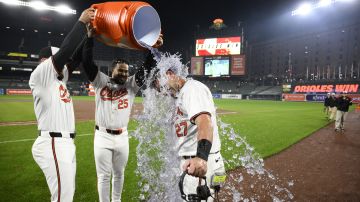 Baltimore Orioles' James McCann (27) gets doused by Anthony Santander (25) and Colton Cowser, left, after a baseball game against the Kansas City Royals, Wednesday, April 3, 2024, in Baltimore. McCann hit a walk-off two RBI single in the ninth. The Orioles won 4-3. (AP Photo/Nick Wass)