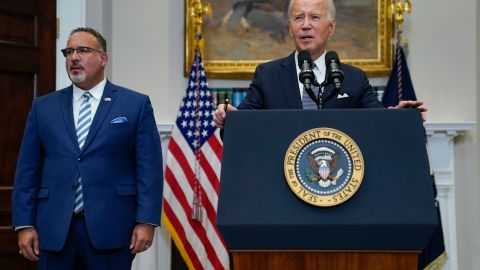 FILE - President Joe Biden speaks as Education Secretary Miguel Cardona listens at the White House, June 30, 2023, in Washington. Biden is traveling to Wisconsin Monday, April 8, 2024, to announce details of a new plan to help millions of people with their student loan debt. Last year, the U.S. Supreme Court foiled Biden's plan to provide hundreds of billions of dollars in student loan debt relief to millions. The visit comes a week after primary voting in the Midwest battleground state highlights weakness for him and Republican challenger Donald Trump. (AP Photo/Evan Vucci, File)