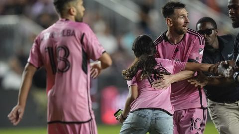 Inter Miami forward Lionel Messi (10) reacts as a young fan runs onto the field to reach him before being carried off by security during the second half of an MLS soccer match against the Colorado Rapids, Saturday, April 6, 2024, in Fort Lauderdale, Fla. (AP Photo/Rebecca Blackwell)