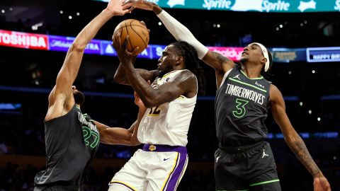 Los Angeles Lakers forward Taurean Prince, center, is defended by Minnesota Timberwolves center Rudy Gobert (27) and Minnesota Timberwolves forward Jaden McDaniels (3) during the second half of an NBA basketball game, Sunday, April 7, 2024, in Los Angeles. (AP Photo/Etienne Laurent)