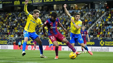 Barcelona's Lamine Yamal, center, is challenged by Cadiz's Robert Navarro, left, during the Spanish La Liga soccer match between Cadiz and Barcelona in Cadiz, Spain, Saturday, April 13, 2024. (AP Photo/Jose Breton)