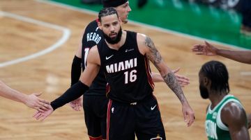 Miami Heat forward Caleb Martin (16) is congratulated by teammates after the Heat's win over the Boston Celtics in Game 2 of an NBA basketball first-round playoff series, Wednesday, April 24, 2024, in Boston. (AP Photo/Charles Krupa)