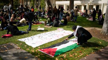 A student places a Palestinian flag on the ground on the USC campus Thursday, April 25, 2024, in Los Angeles. (AP Photo/Jae C. Hong)