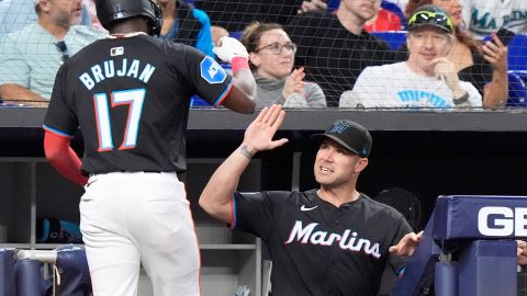 Miami Marlins manager Skip Schumaker, right, congratulates Vidal Brujan (17) after Brujan scored on a single by Nick Fortes during the third inning of a baseball game against the Washington Nationals, Friday, April 26, 2024, in Miami. (AP Photo/Wilfredo Lee)