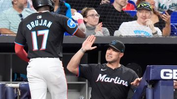 Miami Marlins manager Skip Schumaker, right, congratulates Vidal Brujan (17) after Brujan scored on a single by Nick Fortes during the third inning of a baseball game against the Washington Nationals, Friday, April 26, 2024, in Miami. (AP Photo/Wilfredo Lee)