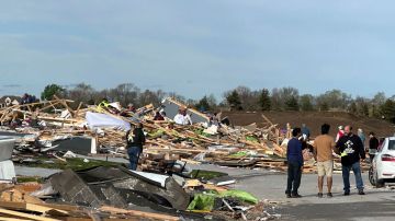 Personas buscan sus pertenencias en los escombros de una casa destruida por un tornado en Elkhorn, Nebraska.