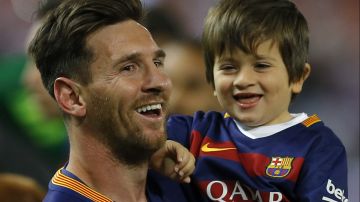 Barcelona's Lionel Messi carries his son as he celebrates after winning the final of the Copa del Rey soccer match between FC Barcelona and Sevilla FC at the Vicente Calderon stadium in Madrid, Sunday, May 22, 2016. Barcelona won 2-0 (AP Photo/Francisco Seco)