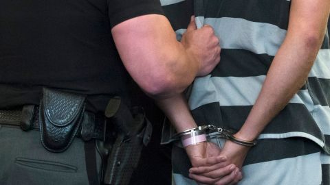 Former University of Cincinnati police Officer Ray Tensing, right, is lead from the courtroom at Hamilton County Courthouse after his arraignment in the shooting death of motorist Samuel DuBose, Thursday, July 30, 2015, in Cincinnati. Tensing, who was indicted and fired from his job on Wednesday, shot and killed Dubose on July 19 after stopping him over a missing license plate. Tensing pleaded not guilty Thursday to charges of murder and involuntary manslaughter. (AP Photo/John Minchillo)