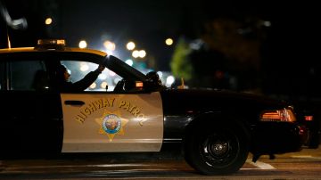 A California Highway Patrol officer sits in his car Thursday, Dec. 3, 2015, near the scene where a police shootout with suspects took place on Wednesday, in San Bernardino, Calif. A heavily armed man and woman opened fire Wednesday on a holiday banquet for his co-workers, killing multiple people and seriously wounding others in a precision assault, authorities said. Hours later, they died in the shootout with police. (AP Photo/Jae C. Hong)