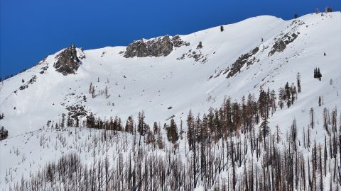 A drone view shows nearby mountain peaks covered with snow near the Phillips Station meadow shortly before the fourth media snow survey of the 2024 season in the Sierra Nevada. The survey is held approximately 90 miles east of Sacramento off Highway 50 in El Dorado County. Photo taken April 2, 2024.   Fred Greaves / California Department of Water Resources