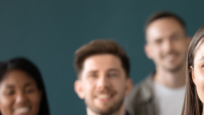 Una joven sonriente extiende su mano para dar la bienvenida al nuevo compañero de trabajo.