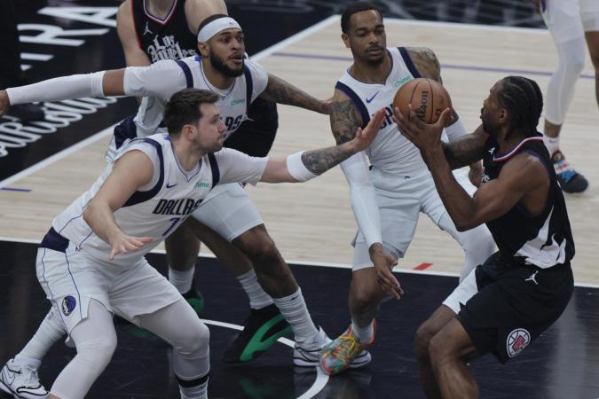 Kawhi Leonard (der,) es defendido por Luka Doncic, de los Mavericks, en duelo de estrellas durante el juego 2 de su serie de playoffs.