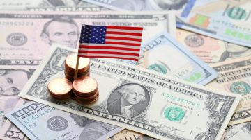 Signo de la bandera de EE.UU. y fondo de billetes y monedas en efectivo en dólares, concepto de economía y finanzas de EE.UU.