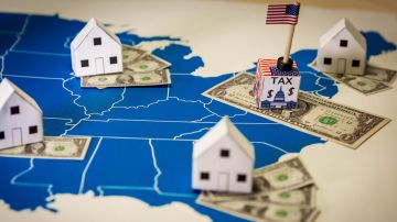 Casas familiares con billetes de dólares e impuestos del gobierno central sobre un mapa de EE.UU.