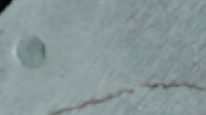 Una mano toma una dona original y fresca de Krispy Kreme.