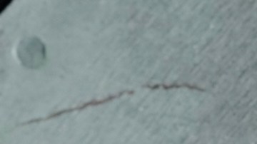 Una mano toma una dona original y fresca de Krispy Kreme.