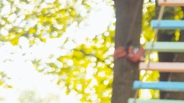 Niña baja por la tirolesa del parque.