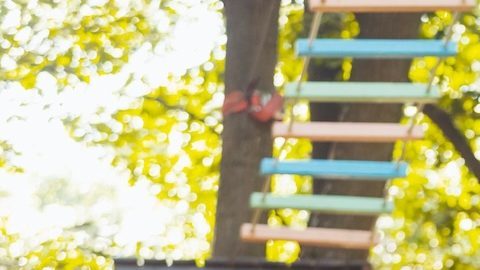 Niña baja por la tirolesa del parque.