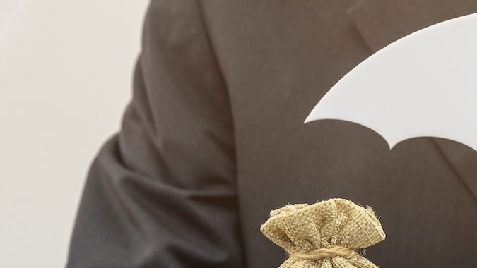 Pareja de jubilados mayores se encuentra en una balanza con una bolsa en dólares estadounidenses.