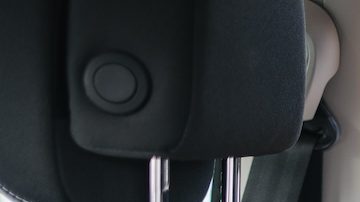 El hombre instala un asiento infantil en el asiento trasero del coche.