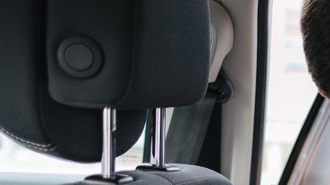 El hombre instala un asiento infantil en el asiento trasero del coche.