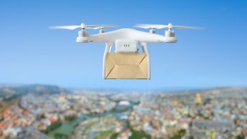 Innovación tecnológica en envíos: concepto de entrega rápida de drones volando con caja de cartón sobre la ciudad.