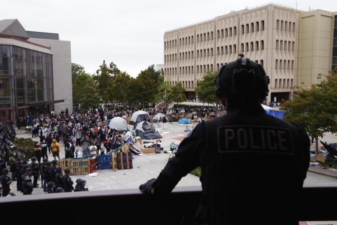 Irvine (United States), 16/05/2024.- A police officer watches a pro-Palestinian encampment of protestors on the campus of the University of California Irvine in Irvine, California, USA, 15 May 2024. Nationwide protests have sprung up across the country on school campuses, many calling for institutions to divest investments in Israel and support a ceasefire in the Gaza conflict. (Protestas) EFE/EPA/CAROLINE BREHMAN
