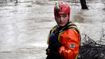 A San Jose Fire Dept. firefighter monitors a overflowing creek as rescues are underway Tuesday, Feb. 21, 2017, in San Jose, Calif. Rescuers chest-deep in water steered boats carrying dozens of people, some with babies and pets, from a San Jose neighborhood inundated by water from an overflowing creek Tuesday. (AP Photo/Marcio Jose Sanchez)