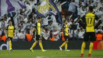 Dortmund's Shinji Kagawa, Marc Bartra, Marcel Schmelzer and Pierre-Emerick Aubameyang walks on the pitch disappointed after Real's third goal during the Champions League Group H soccer match between Real Madrid and Borussia Dortmund at the Santiago Bernabeu stadium in Madrid, Spain, Wednesday, Dec. 6, 2017. (AP Photo/Paul White)