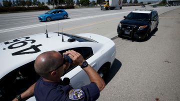 California Highway Patrol officer Matthew Musselmann uses a lidar gun for speed detection along Interstate 5 freeway, Thursday, April 23, 2020, in Anaheim, Calif. The CHP is issuing a lot more tickets to motorists where lanes are wide open during the coronavirus pandemic. From March 19, when the stay-at-home order began, through April 19, officers issued 87% more citations to drivers suspected of speeding in excess of 100 mph. That's compared to the same period last year. The jump in speeding tickets coincides with a 35% decline in traffic volume. (AP Photo/Chris Carlson)