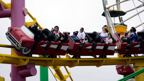 Visitors ride a roller coaster, Thursday, May 13, 2021, in Santa Monica, Calif. Counties in California are waiting for guidance from the state after the federal government on Thursday said that fully vaccinated people can quit face coverings and social distancing in most situations. California's Department of Public Health did not immediately respond to questions about whether it would adopt new guidance announced by the Centers for Disease Control and Prevention. (AP Photo/Marcio Jose Sanchez)