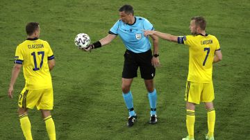 Referee Slavko Vincic, center, holds the ball during the Euro 2020 soccer championship group E soccer match between Spain and Sweden, at La Cartuja stadium in Seville, Spain, Monday, June 14, 2021. (Julio Munoz/Pool via AP)