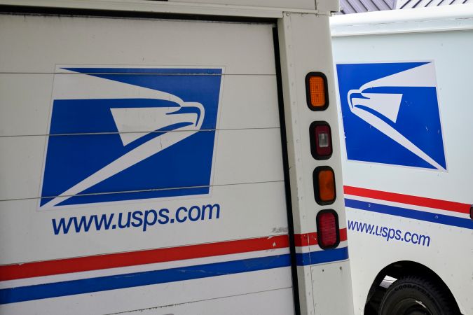 FILE - In this Aug. 18, 2020, photo, mail delivery vehicles are parked outside a post office in Boys Town, Neb. One in five of the first batch of next-generation U.S. Postal Service delivery vehicles will be electric-powered, officials said Thursday, March 24, 2022. The Postal Service formally placed its initial $2.98 billion order for 50,000 vehicles with at least 10,019 of them being battery-electric vehicles. (AP Photo/Nati Harnik, File)