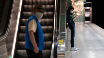 Two commuters wait for a train to arrive at a Metro station in Los Angeles, Wednesday, July 13, 2022. Los Angeles County, the nation's largest by population, is facing a return to a broad indoor mask mandate if current trends in hospital admissions continue, health director Barbara Ferrer told county supervisors Tuesday. (AP Photo/Jae C. Hong)