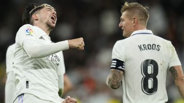 Real Madrid's Federico Valverde, left, celebrates with Toni Kroos after scoring his side's third goal during the Spanish La Liga soccer match between Real Madrid and Sevilla at the Santiago Bernabeu stadium in Madrid, Saturday, Oct. 22, 2022. (AP Photo/Manu Fernandez)