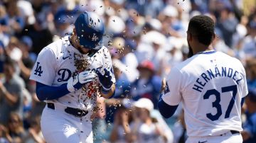 Los Angeles Dodgers' Andy Pages, left, is hit with sunflower seeds thrown by Teoscar Hernández (37) after hitting a three-run home run during the fifth inning of a baseball game against the New York Mets in Los Angeles, Sunday, April 21, 2024. This was Pages' first MLB home run. (AP Photo/Kyusung Gong)