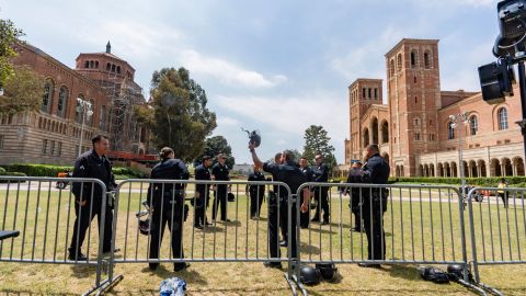 Police retrieve their helmets and riot gear laying next to steel barriers set up outside Royce Hall at the UCLA campus in Los Angeles on Friday, May 3, 2024. More than 200 people were taken into custody at the university early Thursday, after hundreds of protesters defied orders to leave, some forming human chains as police fired flash-bangs to break up the crowds. (AP Photo/Damian Dovarganes)