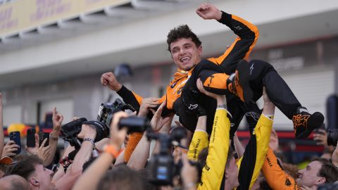 integrantes de la escudería McLaren levantan a Landon Noriris para celebrar su triunfo en el Gran Premio de Miami.