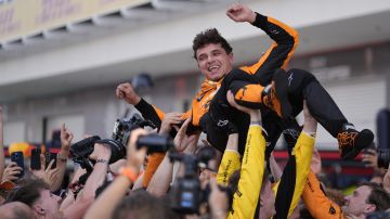 integrantes de la escudería McLaren levantan a Landon Noriris para celebrar su triunfo en el Gran Premio de Miami.