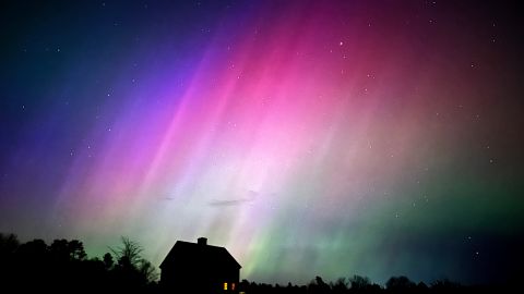 La aurora boreal brilla en el cielo sobre una granja, la noche del viernes 10 de mayo de 2024, en Brunswick, Maine.