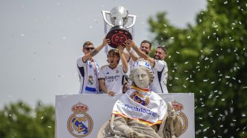 Jugadores del Real Madrid celebran el título de LaLiga poniéndole la bufanda a la diosa Cibeles.