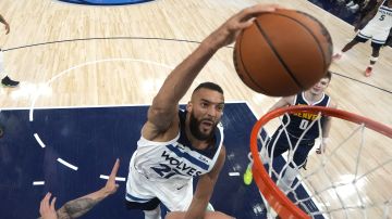 Minnesota Timberwolves center Rudy Gobert (27) dunks against Denver Nuggets center Nikola Jokic, bottom, during the second half of Game 4 of an NBA basketball second-round playoff series, Sunday, May 12, 2024, in Minneapolis. (AP Photo/Abbie Parr)