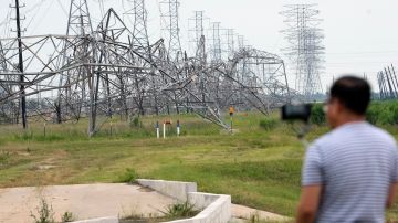Un residente registra la caída de líneas eléctricas en su vecindario después de una fuerte tormenta en Cypress, cerca de Houston.