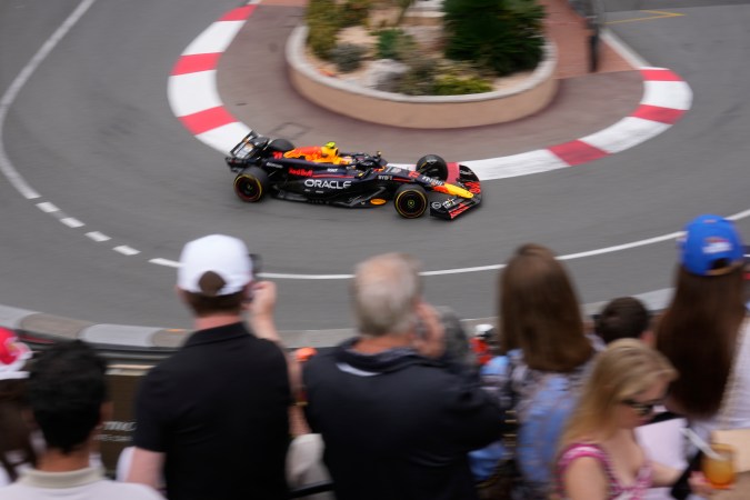 Los aficionados aprovechan una curva cerrada del circuito urbano de Montecarlo para poder apreciar el monoplaza de Sergio "Checo" Pérez sobre la pista.